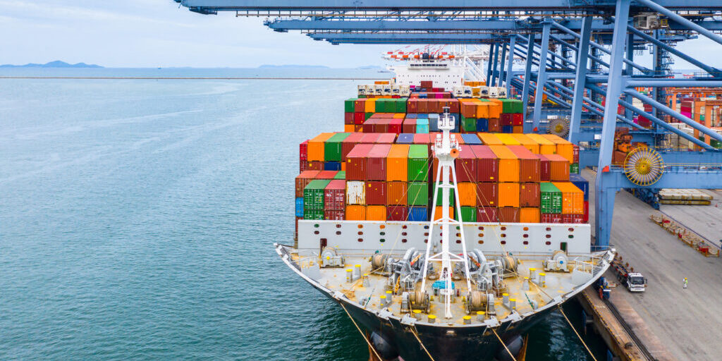 Cargo ship terminal, Unloading crane of cargo ship terminal, Industrial port with containers and container ship.